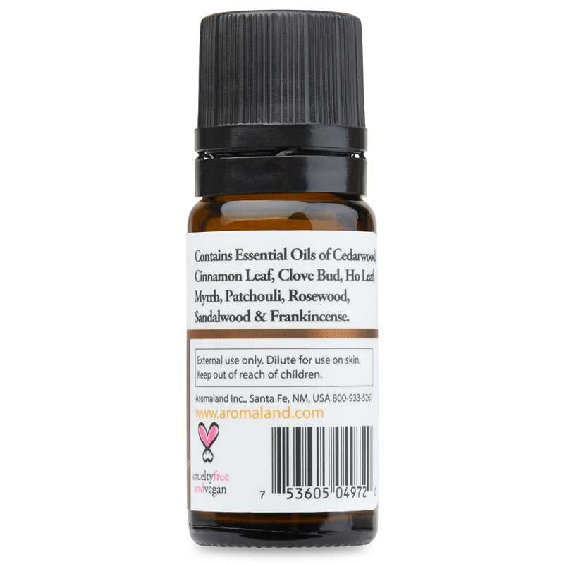 A small amber glass bottle with a black ribbed cap, shown from the back against a plain white background. The white label lists essential oil ingredients and includes a barcode and small pink text for aromaland.